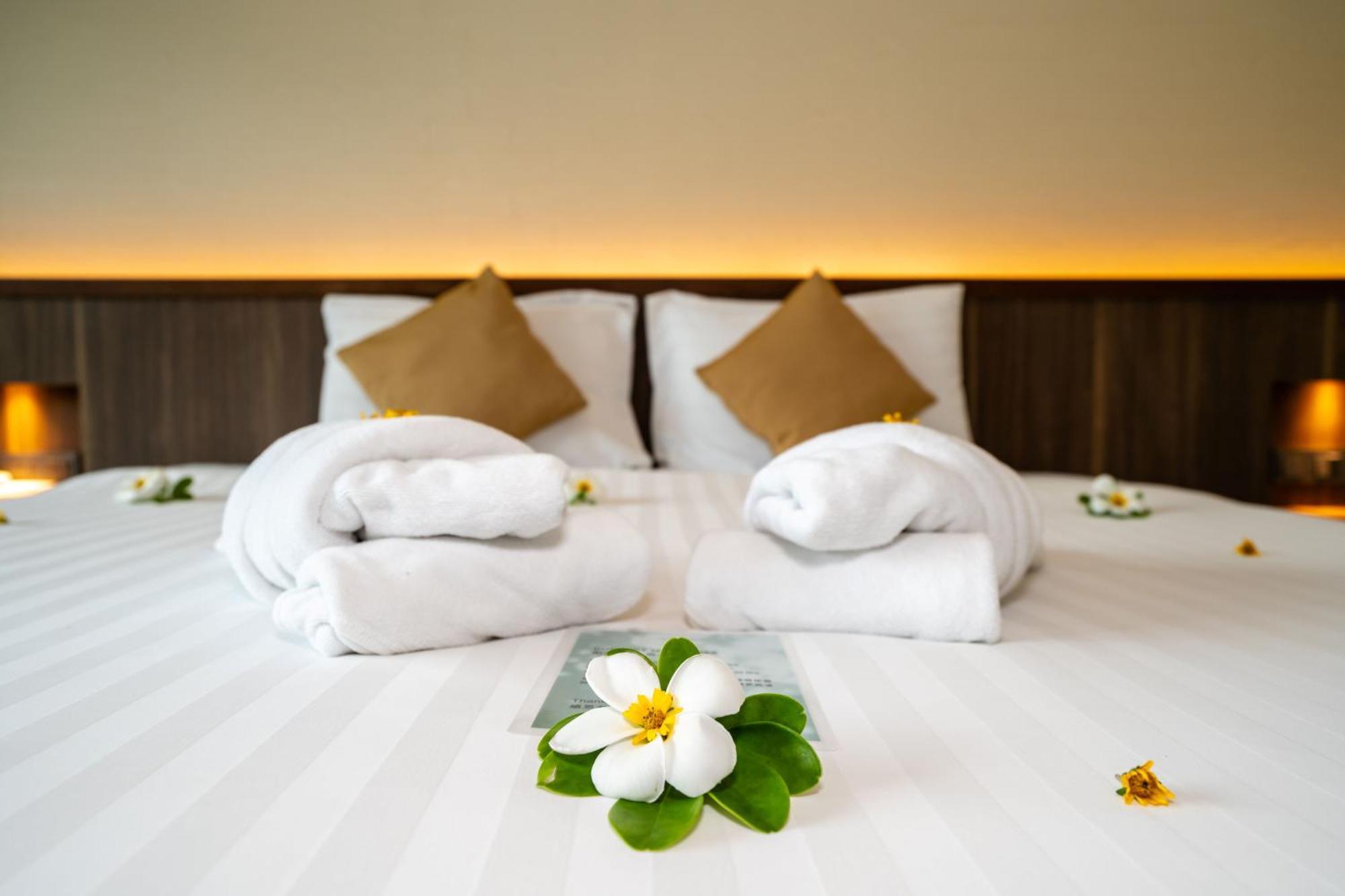 Le Resort And Villas Rawai Zewnętrze zdjęcie A bed with towels and flowers